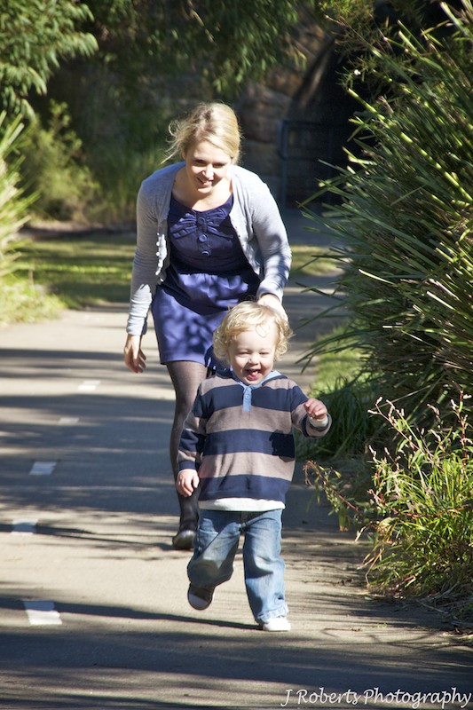 Mum chasing little giggling boy - family portrait photography sydney